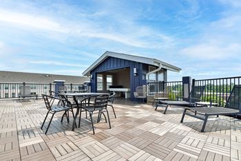A patio with a table and chairs is set up on a rooftop.